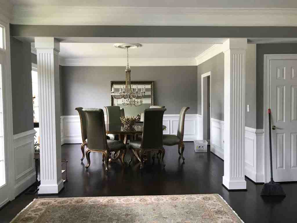 Stylish dining area with vintage chairs, chandelier, and detailed wall trim, showcasing sophisticated interior design.