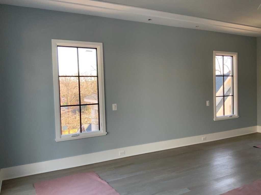 Bright, airy room with natural sunlight streaming through black-framed windows.