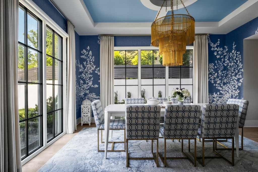 A sculptural gold chandelier draws the eye upward to the reimagined tray ceiling.