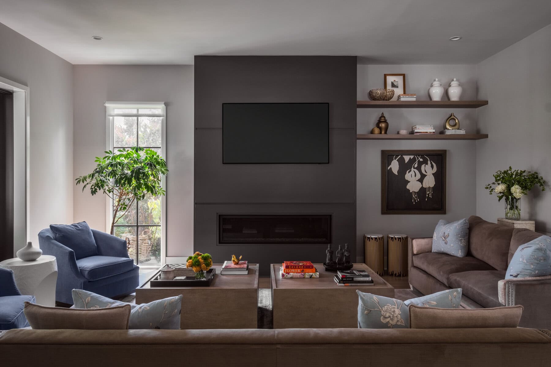 Curated shelves soften the clean lines of the fireplace wall.