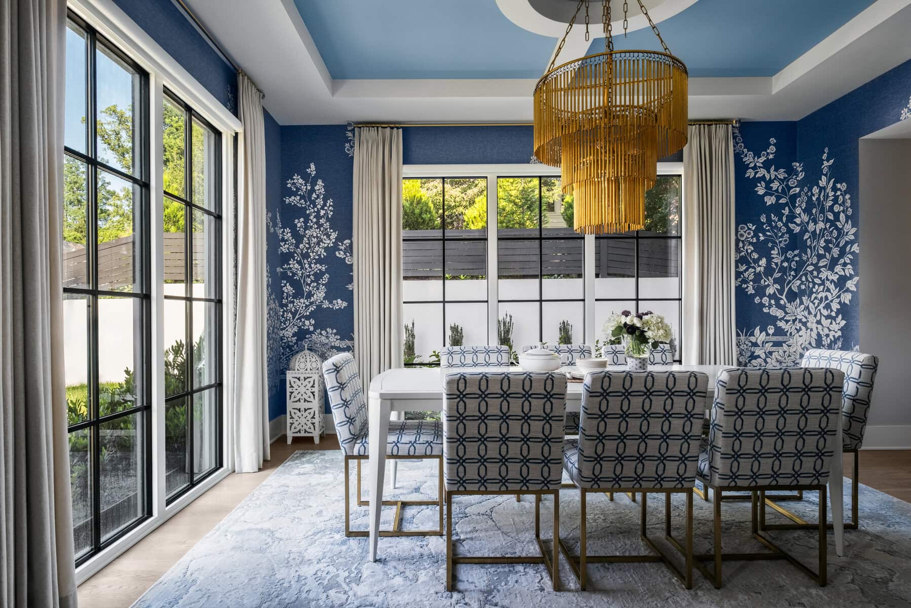 A sculptural gold chandelier draws the eye upward to the reimagined tray ceiling.